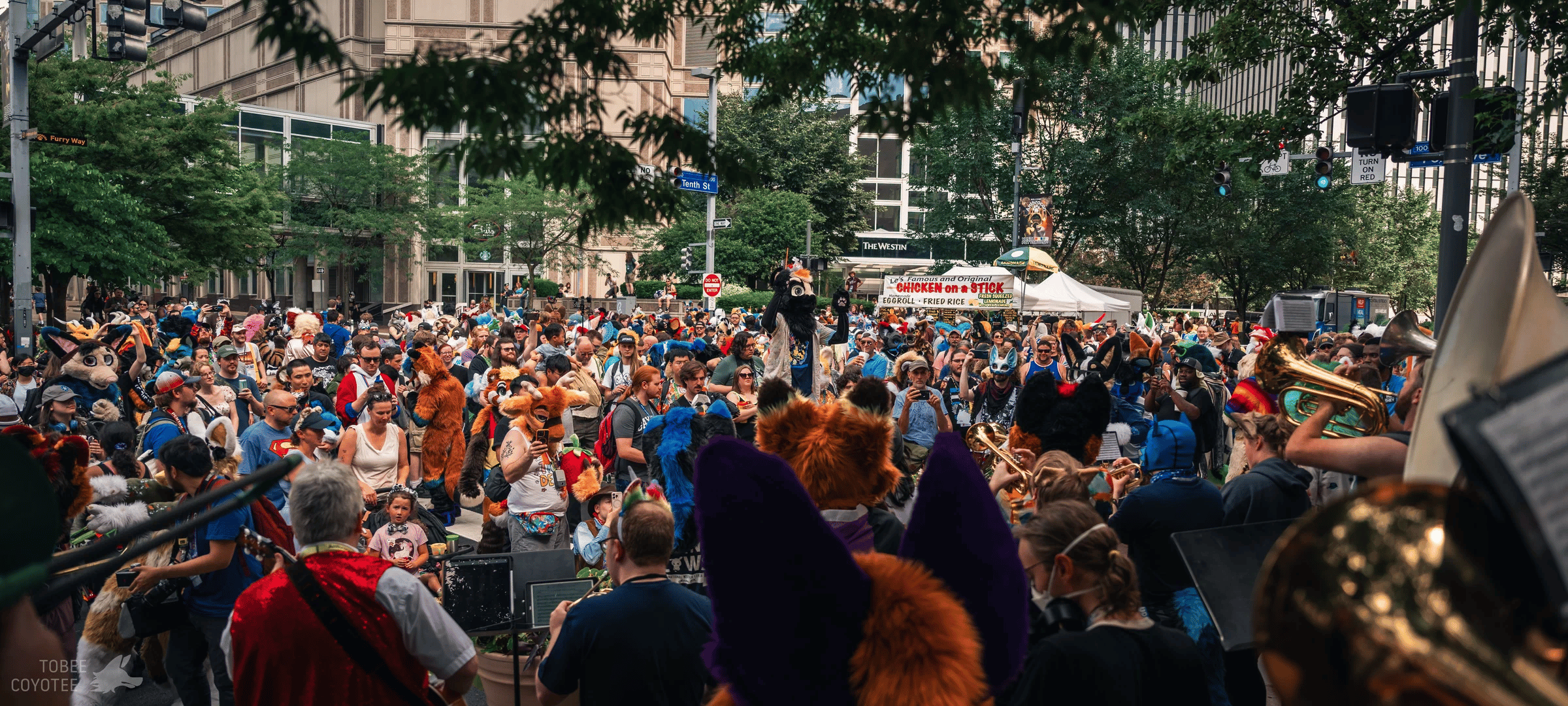A large Anthrocon outdoor crowd gathered around musicians and fursuiters in downtown Pittsburgh