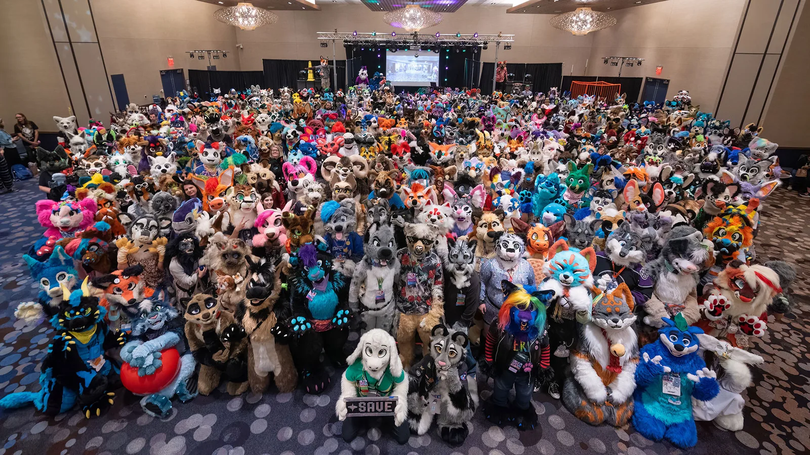 Fursuiters gathering at a furry convention, representing the community scale behind convention charity fundraising